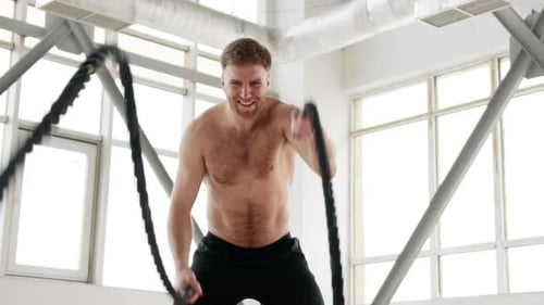 Muscular Man Working Out with Battling Ropes