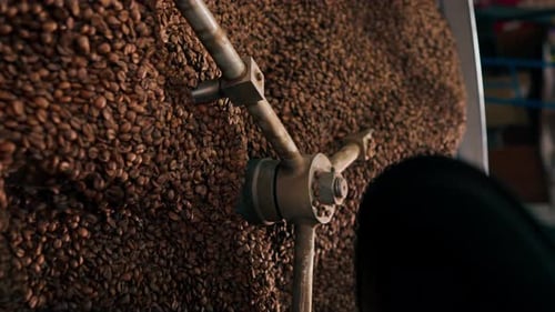 Vertical Video Closeup of a Coffee Roasting Factory Inside Drum Roasting Stirring Coffee