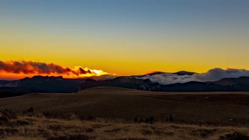 Colorful Sunset Over Mountain Range With Thick White Clouds Swirling Around, Orange Sunset