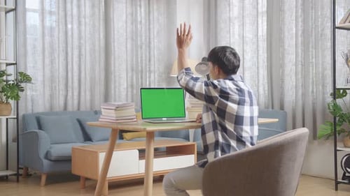 Asian Teenager Learning Online From Laptop With Green Mock Up Screen, Raising Hand Distance Learning