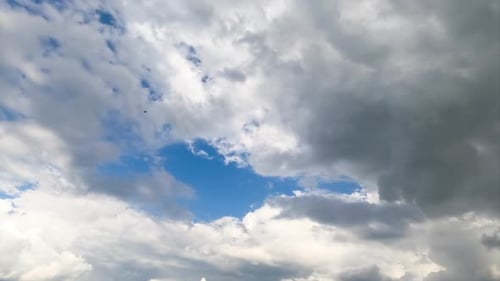 Heavenly beautiful cloudscape moving in the air. Fluffy white clouds in the rays of bright sun.