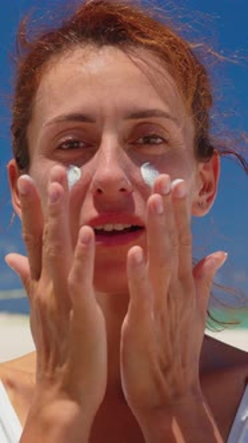 Vertical Video Closeup Beauty Portrait of Young Gorgeous Woman Applies Sun Cream on Her Face Enjoys