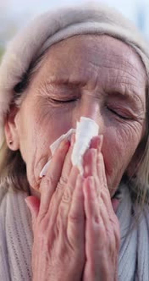 Senior Woman Blowing Her Nose with Tissue