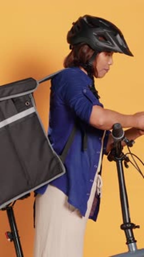 Woman with Folding Bicycle Checking Cell Phone