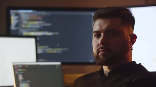 Portrait Shooting of a Young IT Specialist A Web Developer is Sitting in His Office in Front of