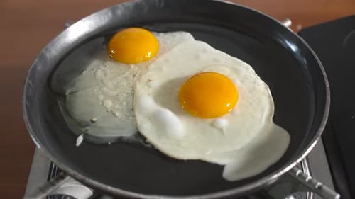 chef cracking egg in hot pan for cooking. Fried egg in iron pan.