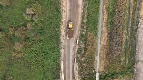 Aerial Shot of Yellow Dump Trucks Transporting Soil
