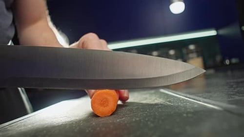 Slow Motion Video Closeup of Cutting Carrots Into Circles on a Cutting Board