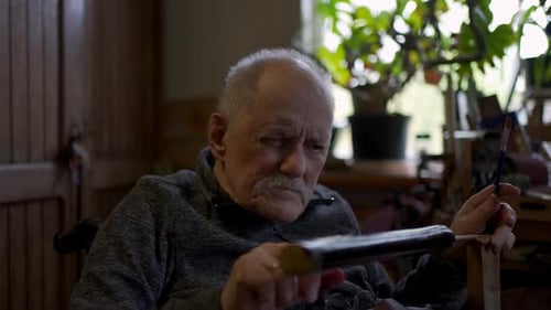 Elderly Male Master Works in His Workshop Restoring Japanese Sword