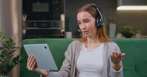 Woman With Tablet Talking on Video Call At Home