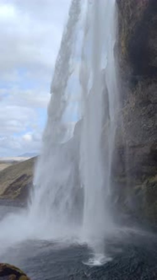 Vertical Shot From Behind Huge Waterfall With Water Mist
