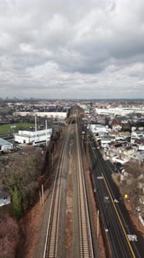 Queens new york drone view along straight railway cutting through suburban new jersey, houses and