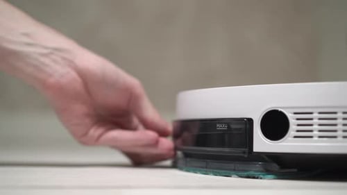 Person Adding Water Tank to Robot Vacuum