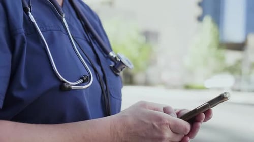 Nurse Texting on Phone in City Center Adult