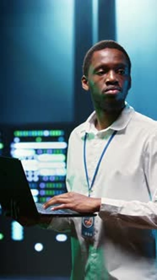 Young Adult Holding Laptop in Futuristic Data Center