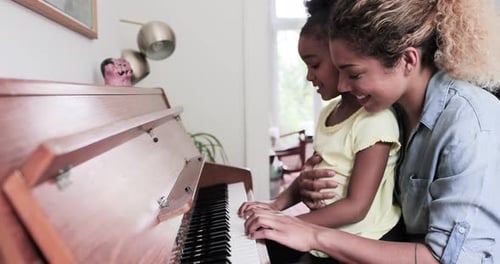 Child Learns Piano with Adult Guidance and Support