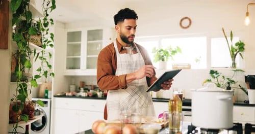 Young Adult Checks Recipe on Tablet in Kitchen