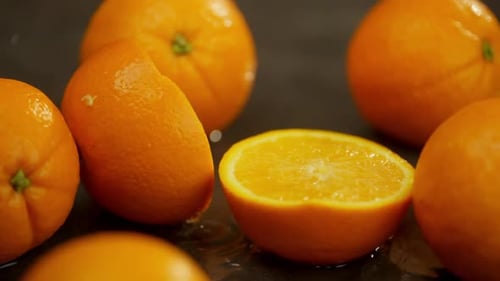 Juicy Oranges and Sliced Halves on Dark Background