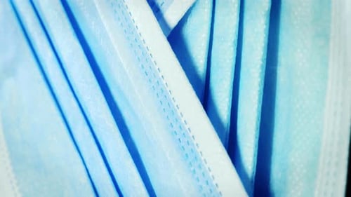Blue facial protective medical mask rotating, close-up. Vertical video