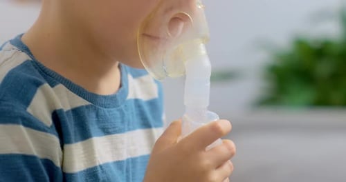 Young Child Uses Nebulizer Mask for Respiratory Treatment