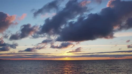 Timelapse with Sunset and Cumulus Clouds Flying High in a Beautiful Blue Sky Sun Dawn in the Sea
