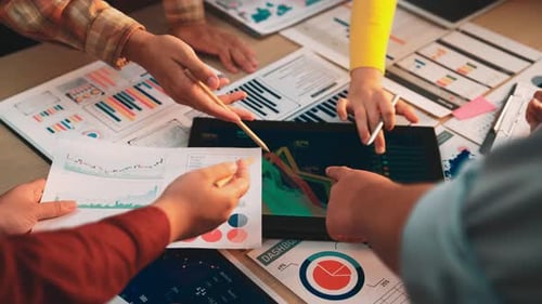 Business Team Analyzing Charts and Graphs on Tablet