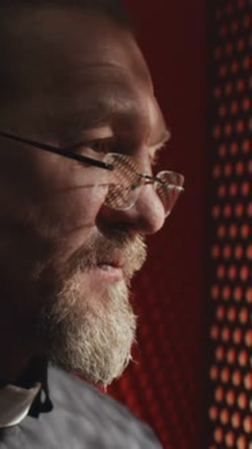 Bearded Man with Glasses Speaking in Booth