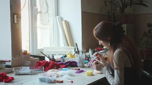 Woman Handcrafting Doll at Sunny Workbench