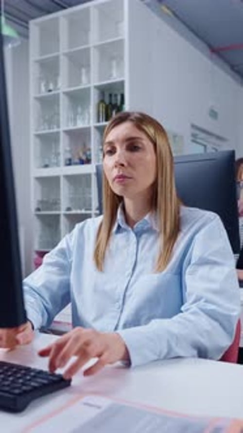 Focused Office Worker Typing on Desktop Computer in Modern Open Plan Workspace Concentrating on