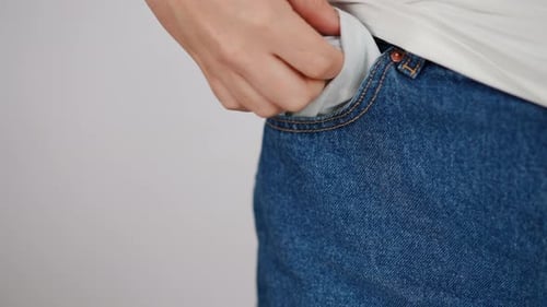 Slow Motion Closeup An Unrecognizable Woman Takes Her Hand Out of Her Blue Jeans Pocket Taking Out