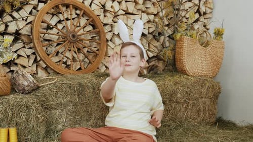 Portrait of Boy with Fluffy Ears Dancing with Hands in Barn