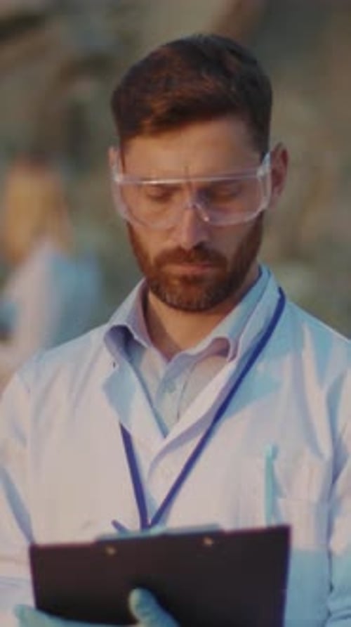 Bearded Man in Lab Coat and Safety Goggles Outside