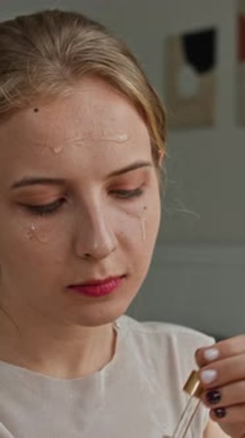 Female Zoomer Applying Serum on Face at Home