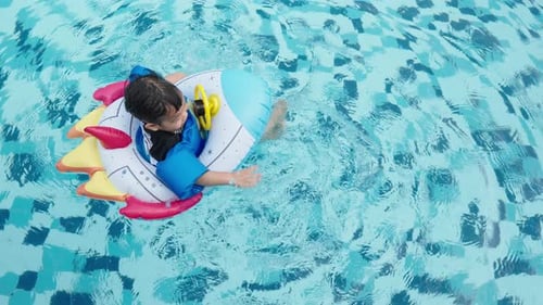Toddler Floating in Rocket Ship in Swimming Pool