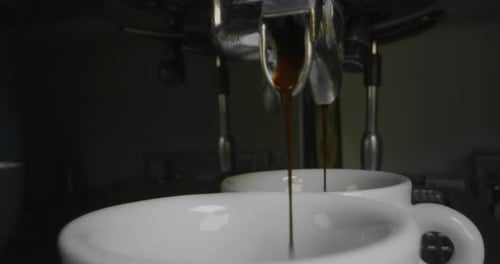 Espresso Pours into Mugs From Metallic Machine