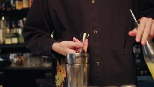 Bartender Make a Whiskey Rum Cocktail Drink for Guests in the Bar Closeup Night Modern Bar with Many
