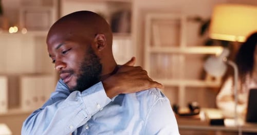 Man Rubs Neck and Shoulder Due to Pain
