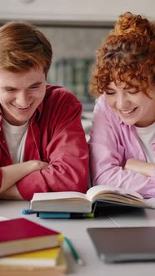 Fröhliche Schüler lesen gemeinsam ein Buch, um nützliches Material zu finden