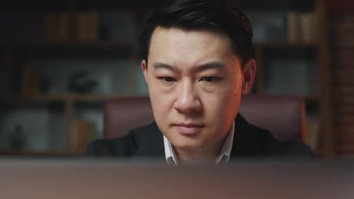 Stressed Man Working at Computer in Office