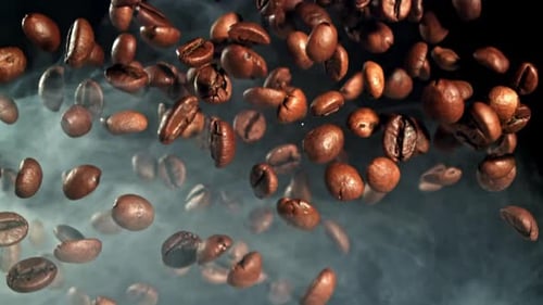 Superzeitlupen-Kaffeebohnen mit Rauch, gefilmt auf einer Hochgeschwindigkeitskamera mit 1000 Bildern pro Sekunde