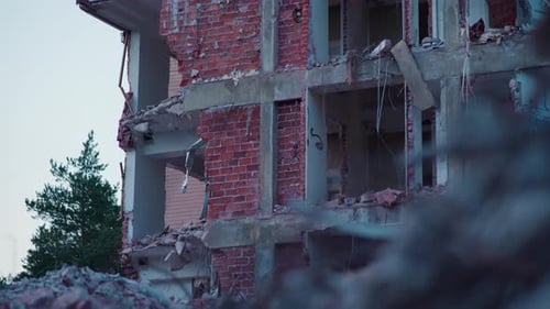 Partially demolished apartment building surrounded by rubble