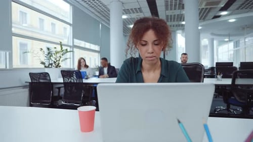 African American businesswoman working on laptop in coworking space