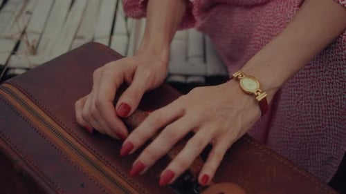 Woman Opening Vintage Suitcase in Rural Setting