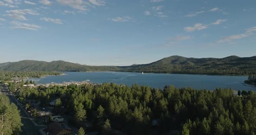 a body of water with trees and mountains in the background