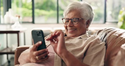 Funny, phone and elderly woman in home for relax, comedy post or scroll in retirement on sofa