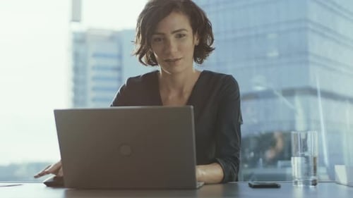 Confident Female Executive Works on a Laptop Sitting at Her Desk in Modern Office with Grandiouse C