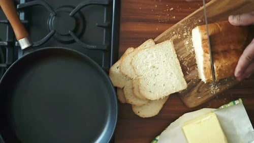 Cutting Bread on Cutting Board, Next to Frypan