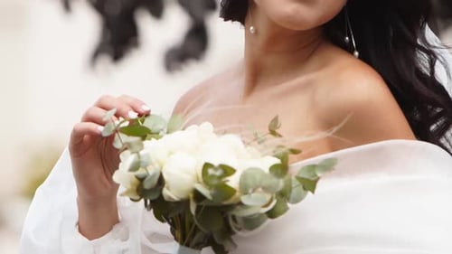 Beautiful Woman Holding Bouquet in Wedding Dress