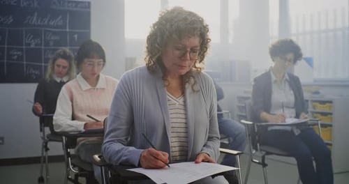 Students Completing Exam in Bright Classroom Setting