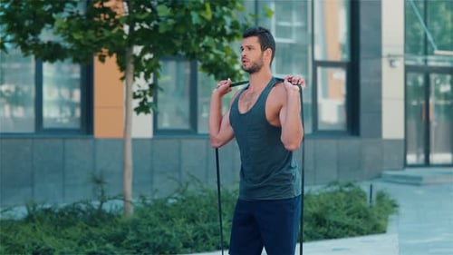 Fit Man Doing Resistance Band Squats Outdoors